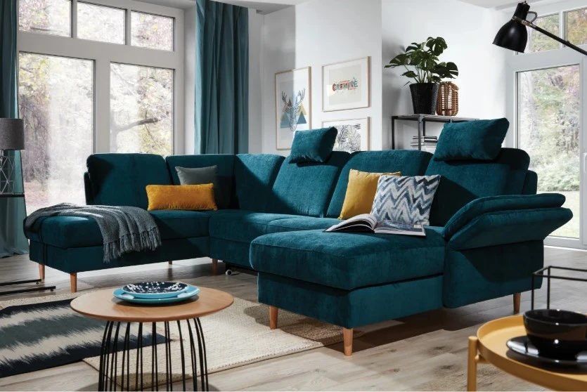 Niebieski narożnik z drewnianymi nóżkami i kolorowymi poduszkami